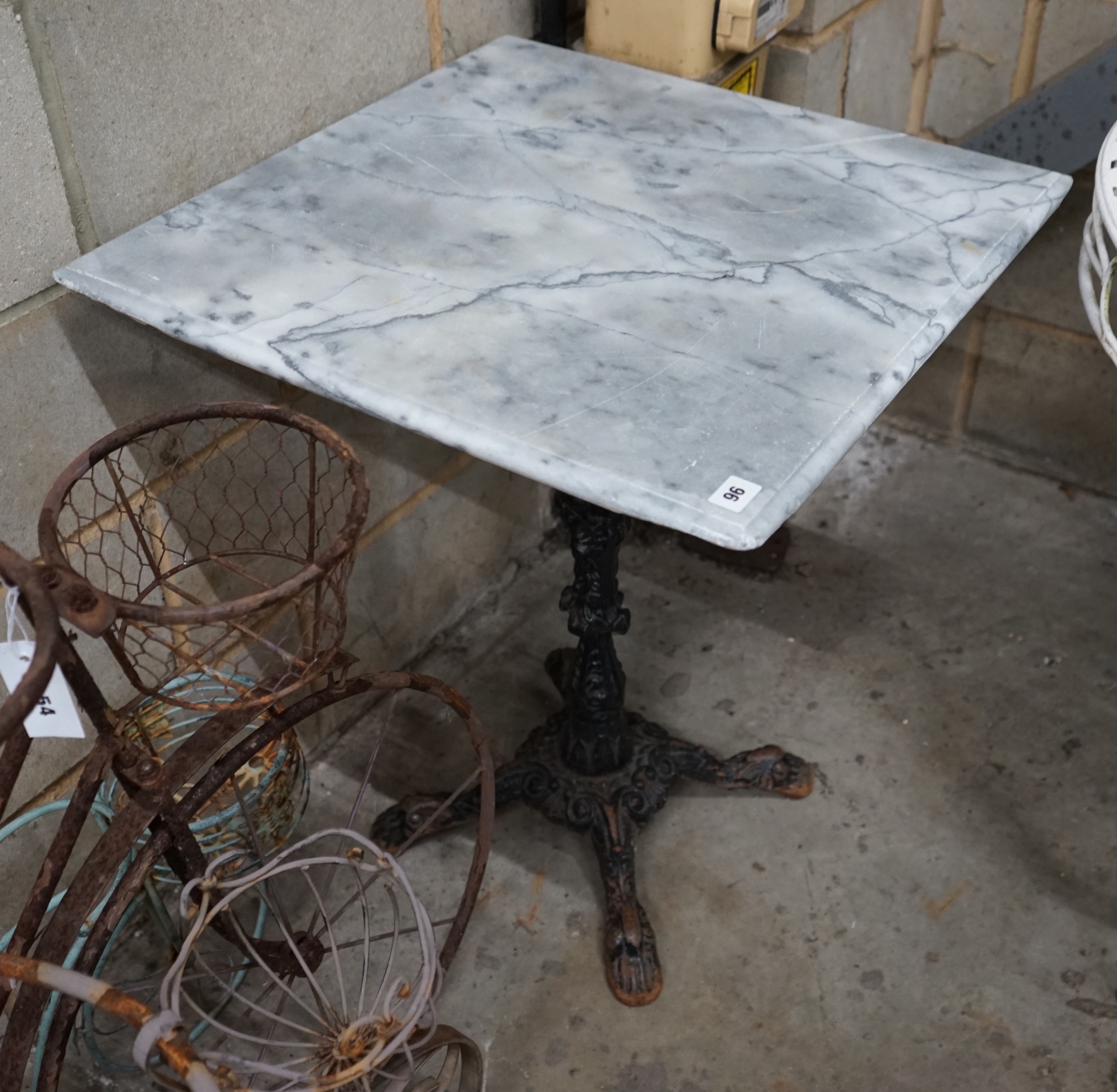 A reconstituted marble and cast iron garden table, width 60cm height 73cm